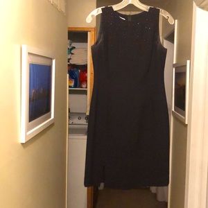 Black, knee-length, simple coattail dress with petite front rhinestones.